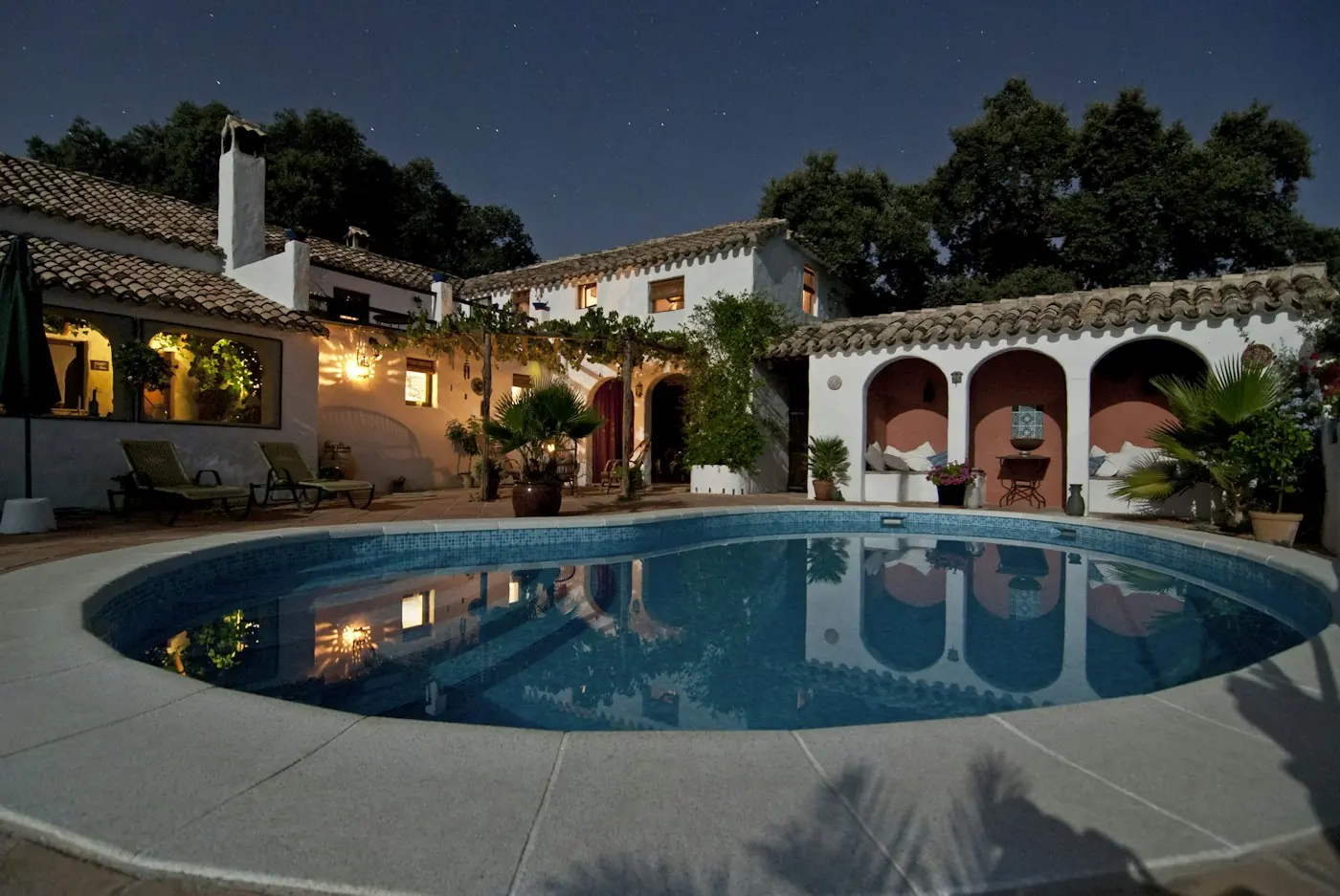 Villa com piscina iluminada ao anoitecer