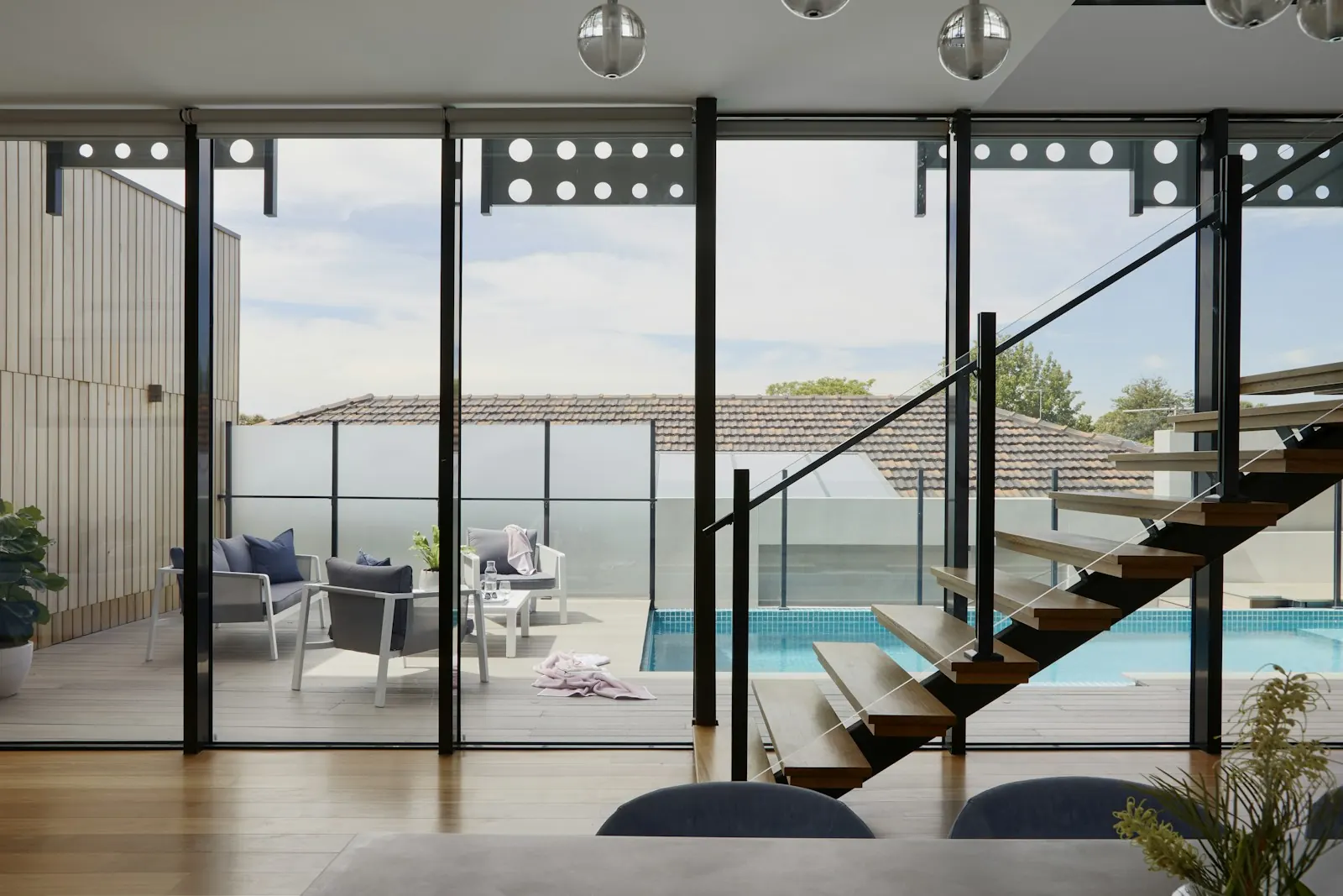 Escada vazada e portas de vidro abertas para a piscina